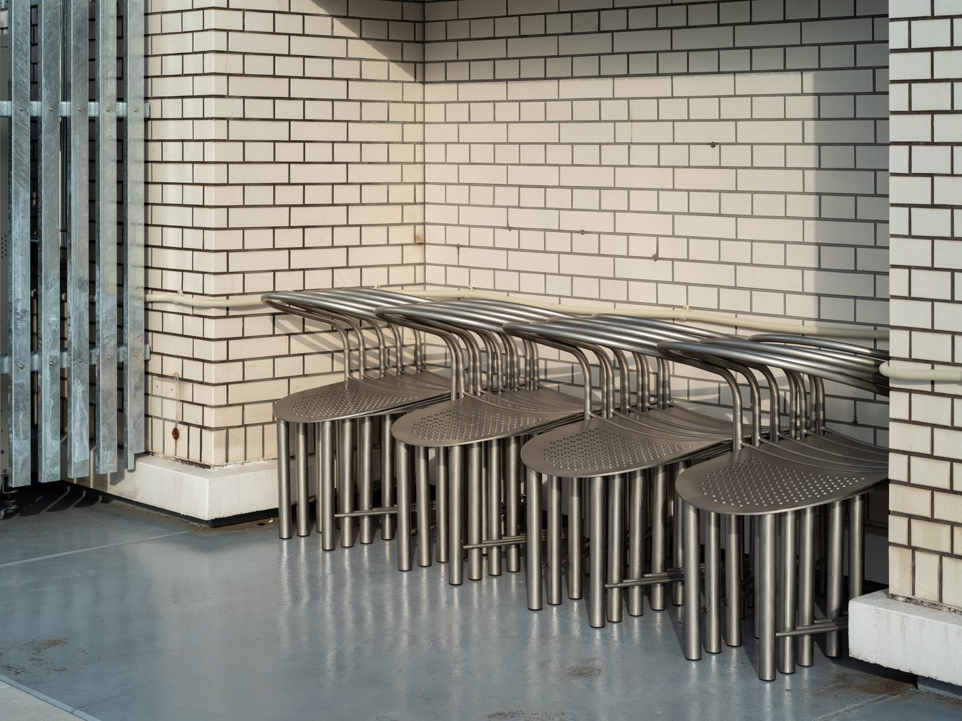 レンガ壁の隅に重ねて片付けられたTRAIN CHAIR